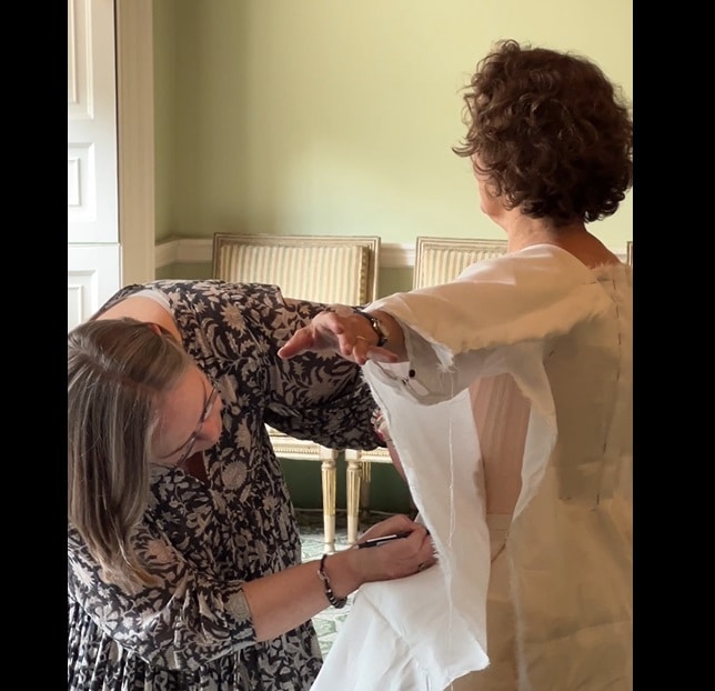 Drawing the shapes of the gown bodice lining, right on the wearer, to ensure the perfect fit. Photo credit: David Fettes.